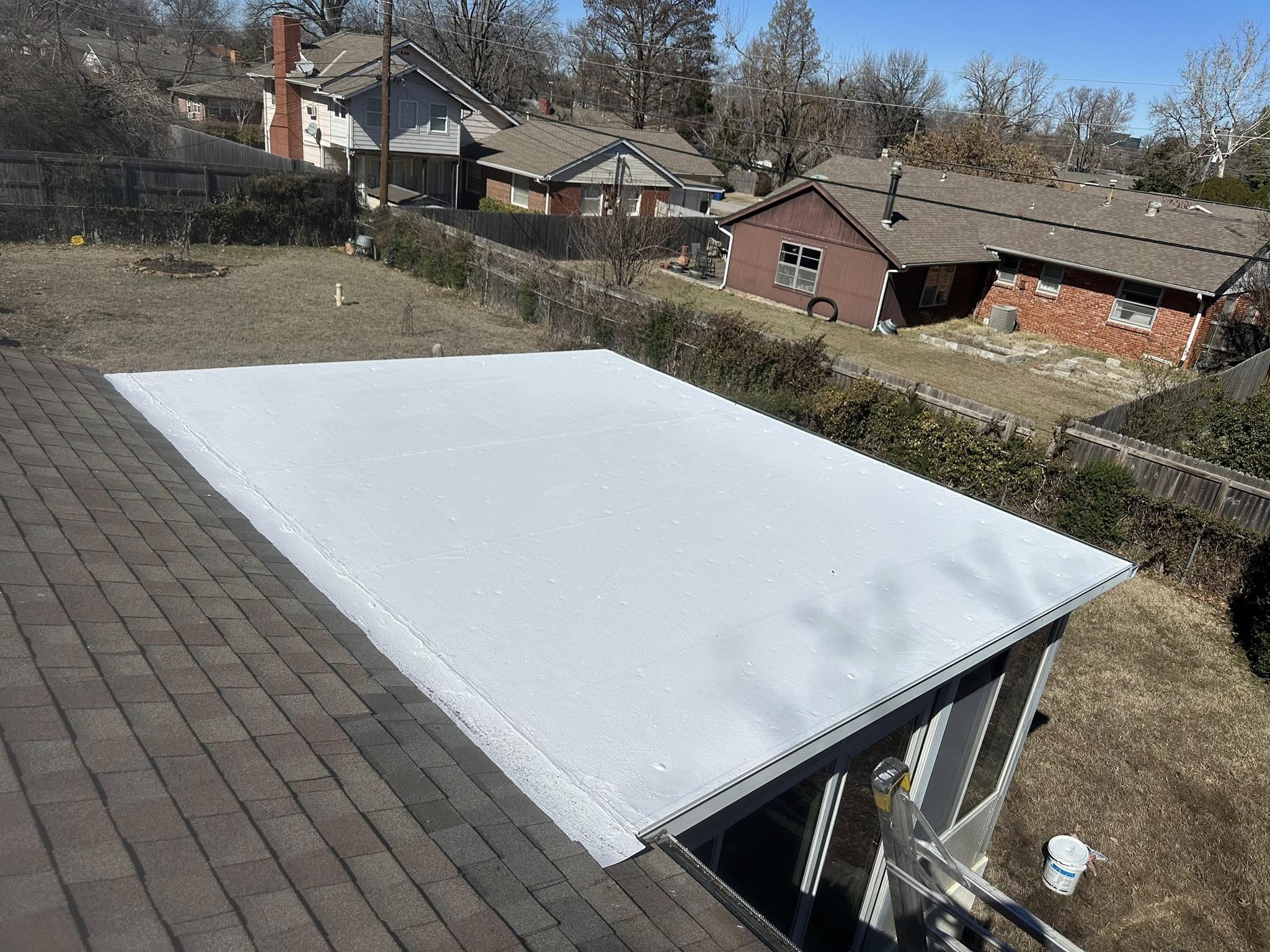 A newly installed white flat roof on a residential building.