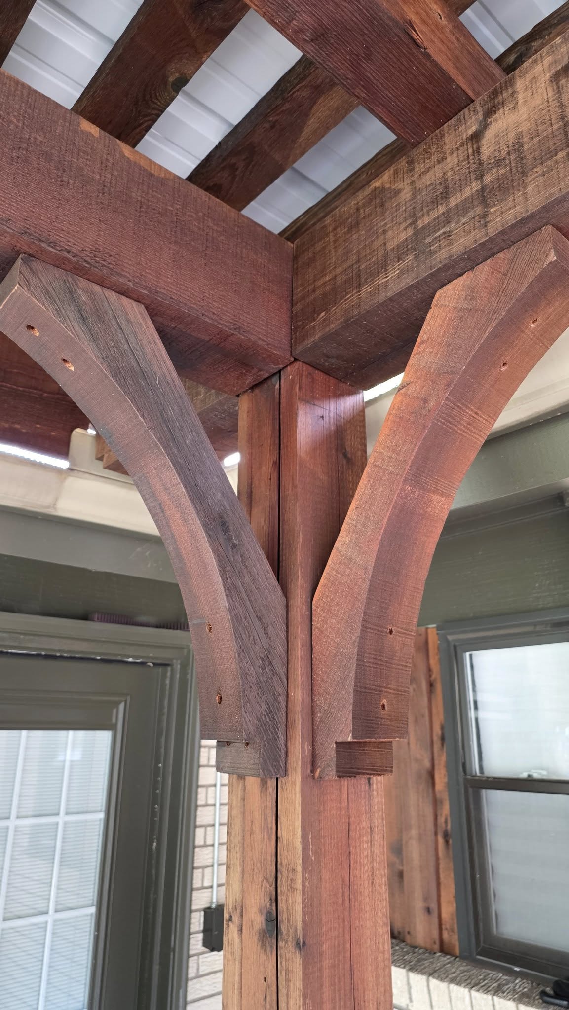A wooden pergola with arched supports is shown outdoors.