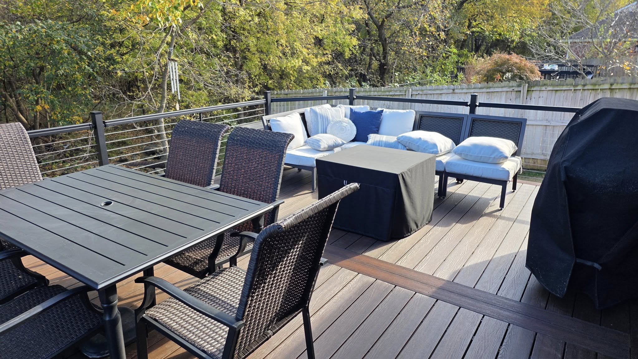 An outdoor deck with furniture, a table, chairs, and a grill is shown.