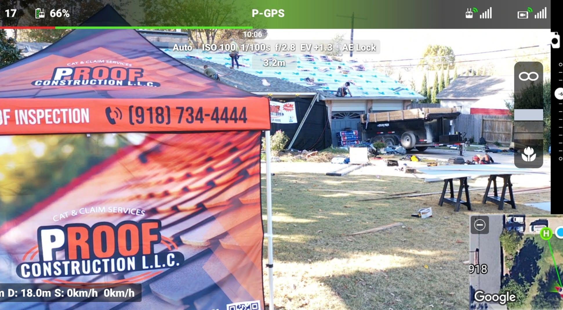 Roofers work on a house with a construction tent and trailer in the yard.