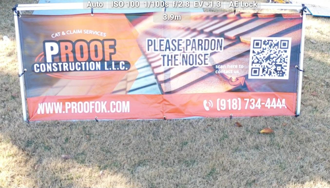 A banner for "Proof Construction L.L.C." is displayed outdoors on a grassy area.